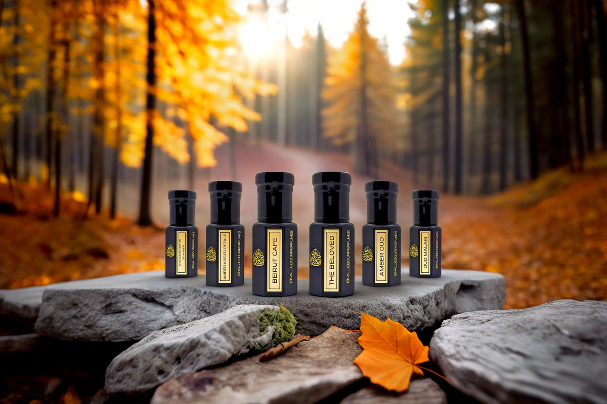 Fall Collection essential oils in black glass bottles with gold labels, set against an autumn forest backdrop.